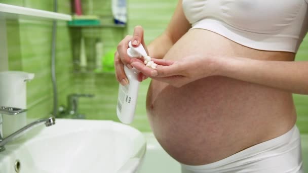 έγκυος κοπέλα λιπαίνει ενυδατώνει με κρέμα κατά ραγάδες στο μπάνιο - Πλάνα, βίντεο