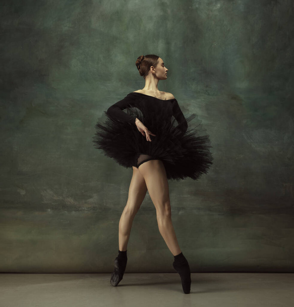 Young graceful tender ballerina on dark studio background - Фото, изображение