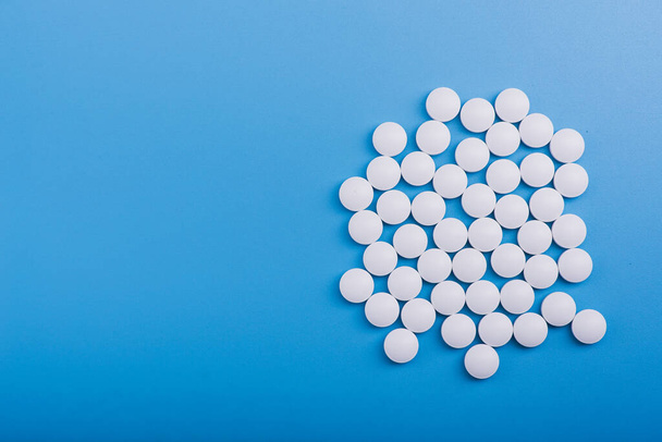 White medical pills on a blue background - Foto, Imagen