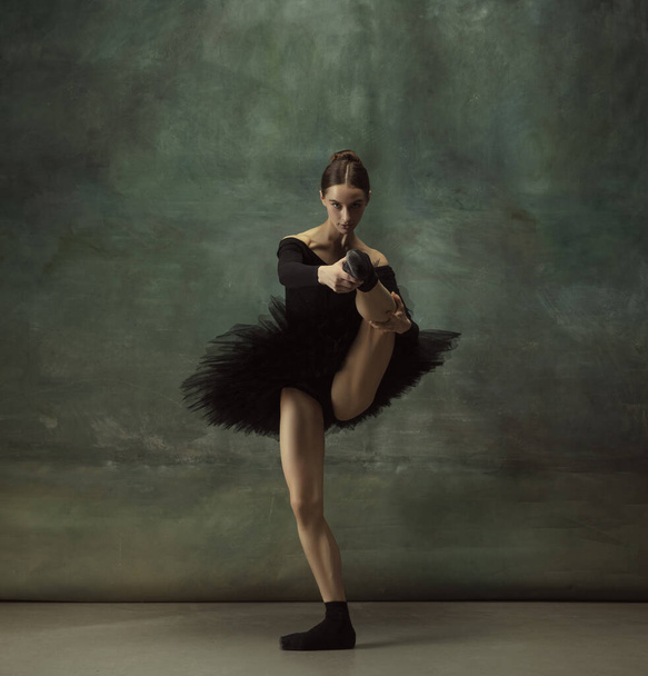 Young graceful tender ballerina on dark studio background - Photo, Image