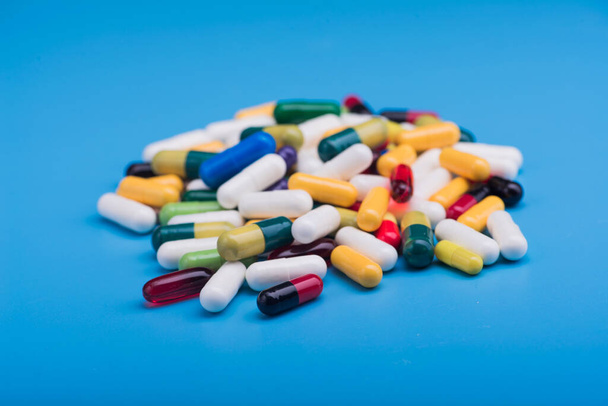 Barevné pilulky a lékařské kapsle na modrém pozadí - Fotografie, Obrázek