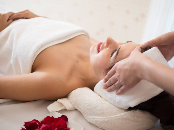 Masajista haciendo masaje la cabeza de una mujer en el salón de spa
 - Foto, imagen