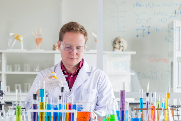 Mladí bělošští vědci provádějící testování pomocí zkumavky při výzkumu ve vědecké laboratoři.  - Fotografie, Obrázek