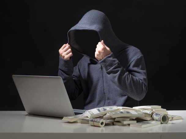 Kybernetický útok s nepoznatelnou kapuci hacker.Hacker krást peníze v kanceláři. - Fotografie, Obrázek