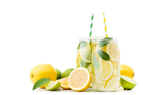 fresh lemonade drink bottle with lemon, lime and mint isolated on white background. Refreshment and cooling beverage - Photo, Image