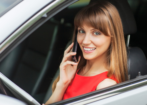 Businesswoman in the car on the phone. - 写真・画像