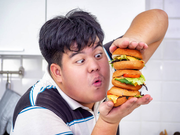 Diet failure of fat man eating fast food unhealthy hamberger. - Фото, зображення