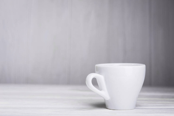 порожня чашка кави на білому дерев'яному столі
 - Фото, зображення