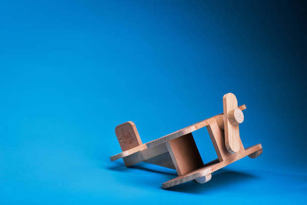 jouet avion en bois sur fond bleu. avion vintage pour enfants - Photo, image