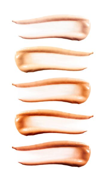 Σετ nude foundation cream smudge για χρωματική απόχρωση, κάθετη. Συλλογή του δείγματος ομαλών εγκεφαλικών επεισοδίων BB cream ή CC cream που απομονώνεται σε λευκό φόντο - Φωτογραφία, εικόνα