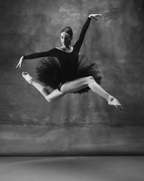 Young graceful tender ballerina on dark studio background - Foto, immagini