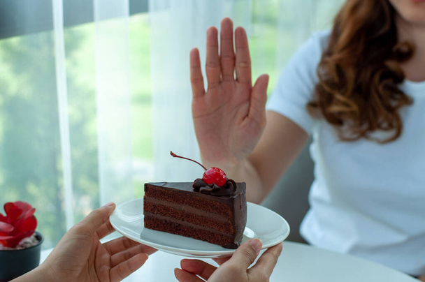 Las mujeres solían empujar el plato de pastel con la gente. No coma postres para bajar de peso. - Foto, imagen