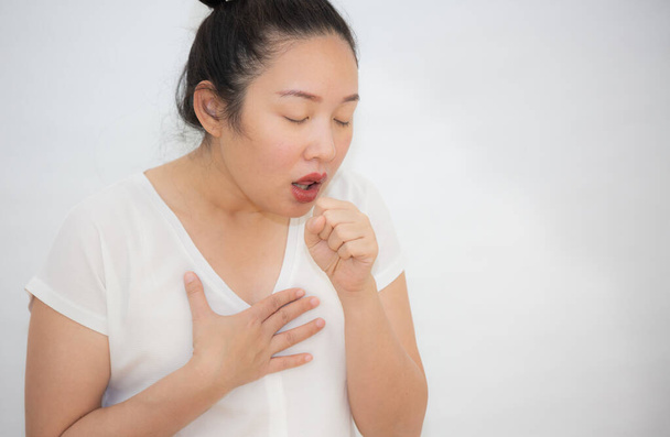 Képek egy ázsiai nőről, aki köhög és tüsszent egy bakteriális fertőzés miatt a nyakában, fehér alapon. - Fotó, kép