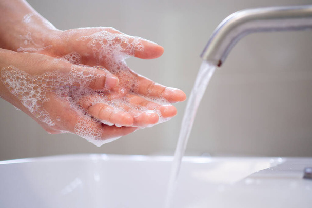 Lavez-vous les mains avec du savon, évitez les virus et les bactéries dans le robinet avec de l'eau courante. Bonne hygiène avant de manger ou de manipuler des objets publics - Photo, image
