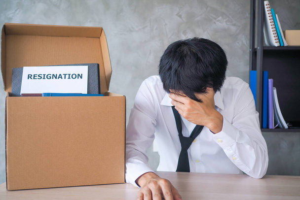 Empresarios están sosteniendo documento de renuncia y embalaje personal con caja de cartón marrón cambio de trabajo, desempleo o concepto de renuncia. - Foto, Imagen