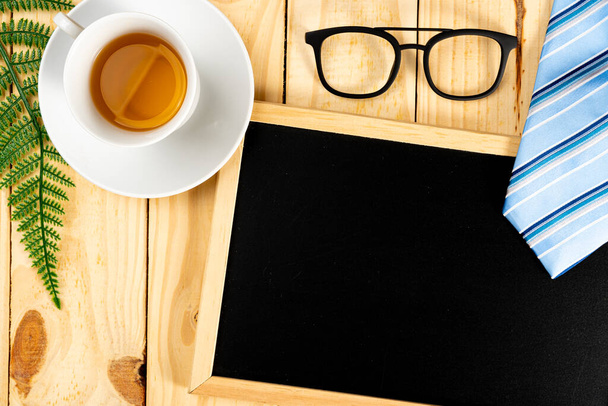 Happy Father Day background concept with blue necktie, glasses, cup of tea and blackboard on wooden background with copy space for text. - Φωτογραφία, εικόνα