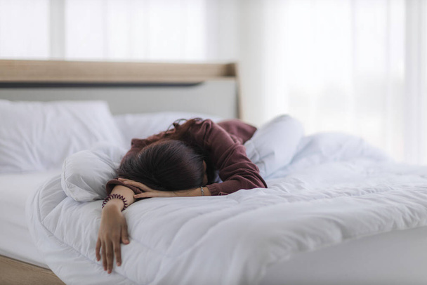 asiatico donna è dormire come un sbornia da un partito o addormentato da esaurimento in il suo letto in il camera da letto fino il mattina
. - Foto, immagini