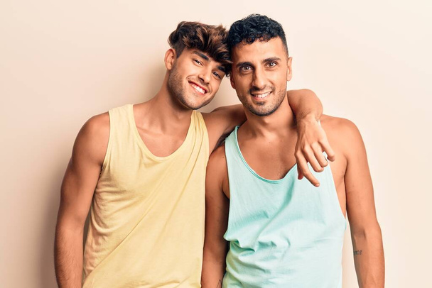 Mladý gay pár v neformálním oblečení se šťastným a chladným úsměvem na tváři. šťastný člověk.  - Fotografie, Obrázek