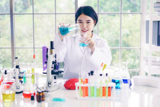 Les scientifiques expérimentent avec des produits chimiques colorés dans les béchers
. - Photo, image