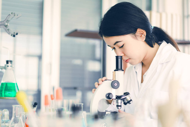 Mladí vědci se podívají do mikroskopu v laboratoři, aby provedli nějaký výzkum. - Fotografie, Obrázek