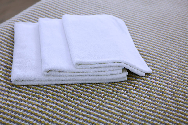 Three Terry-cloth white towels lie in a pile. The view from the top. Copy space. The concept of the hotel business. - Фото, изображение