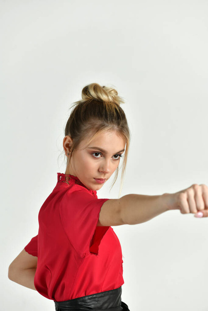 belle fille dans un costume rouge-noir fait des exercices dans le style de la vitesse de combat
 - Photo, image