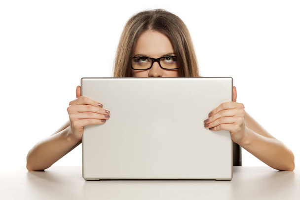 Belles femmes d'affaires jettent un coup d'oeil derrière son ordinateur portable
 - Photo, image