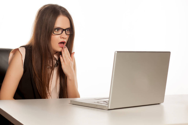 шокированная деловая женщина смотрит на свой ноутбук
 - Фото, изображение