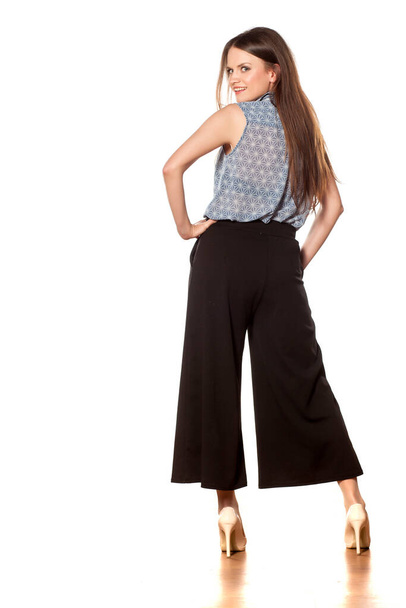 visão traseira de uma jovem mulher bonita com calças largas
 - Foto, Imagem