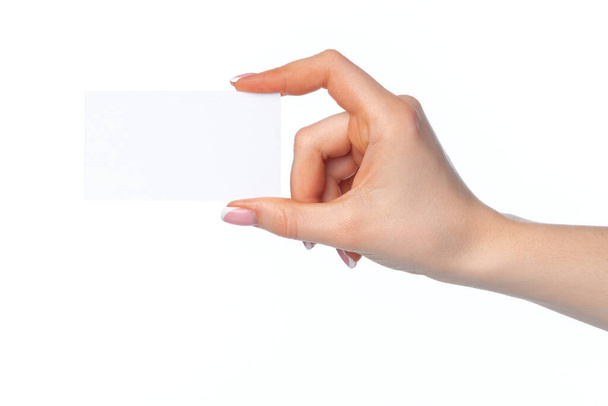 Beautiful female hand holding white business card on white background - Zdjęcie, obraz