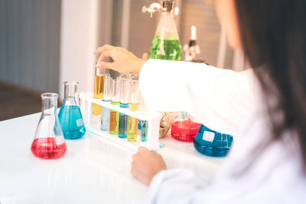 Κοντινό χέρι μαθητή κάνει επιστημονικά πειράματα σε ένα επιστημονικό εργαστήριο. - Φωτογραφία, εικόνα