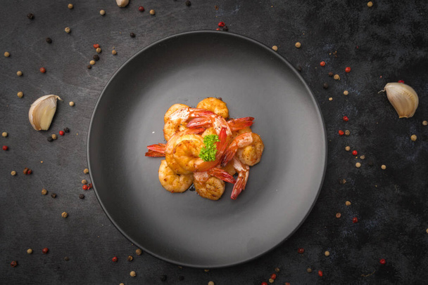 Fried shrimp with deep garlic and pepper on black background. - Zdjęcie, obraz