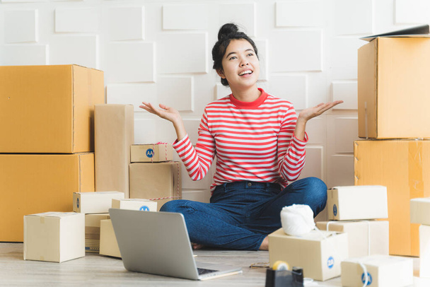 Asijské freelance žena pracující doma a začít malý podnikatel MSP s internetem on-line. Ženy připravují výrobky v krabici, aby se připravily na dodání zákazníkům. - Fotografie, Obrázek