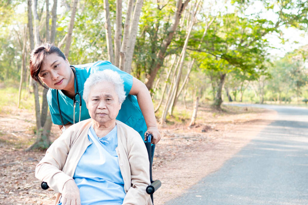 Aide et soins médicaux Aînée asiatique ou vieille dame âgée patiente assise en fauteuil roulant dans le parc de l'hôpital infirmier : concept médical solide et sain
  - Photo, image