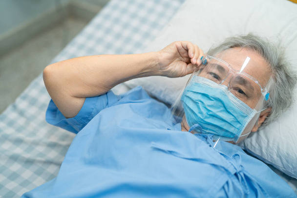 Asiatische Patientin trägt Gesichtsschutz zum Schutz vor Sicherheitsinfektion Coronavirus Covid-19-Virus auf Quarantäne-Krankenhausstation. - Foto, Bild