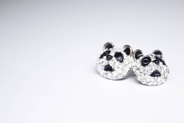Stříbrné náušnice ve tvaru pandy. šperky a příslušenství koncepce. Izolované, kopírujte prostor. Makro snímek - Fotografie, Obrázek