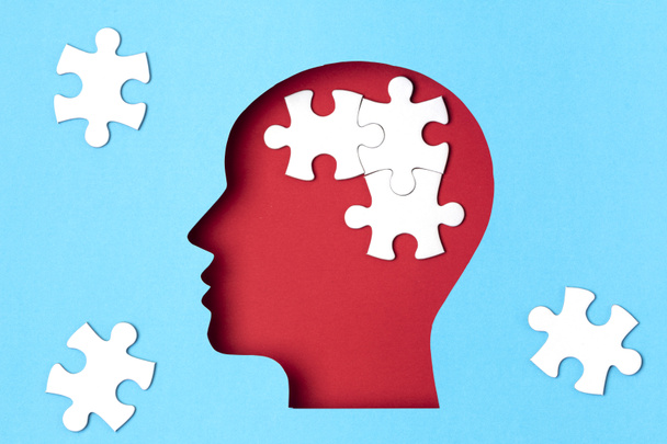 Papercut head with jigsaw puzzle pieces inside. Mental health problems, psychology, memory, logic, thinking process, solution, mental illness concept - Photo, Image