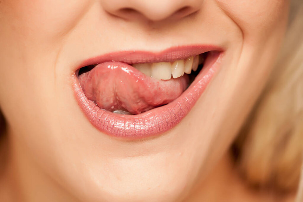 nő nyalogatja száját a nyelvével - Fotó, kép