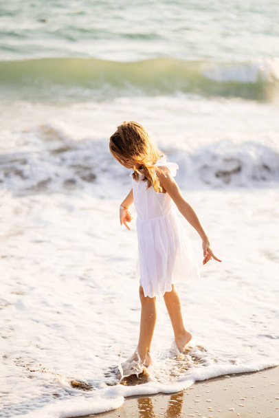 girl walks and fun on sea shore with big waves and strong winds. - Foto, Imagen
