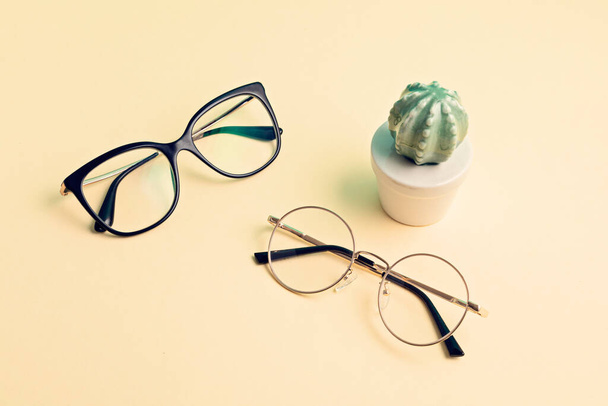Stylish eyeglasses over pastel  background. Optical store, glasses selection, eye test, vision examination at optician, fashion accessories concept. Top view, flat lay - Photo, Image
