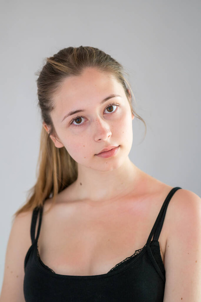 Kameraya bakan uzun doğal sarı saçlı ve pürüzsüz tenli güzel bir genç kızın portresi. Stüdyo çekimi - Fotoğraf, Görsel