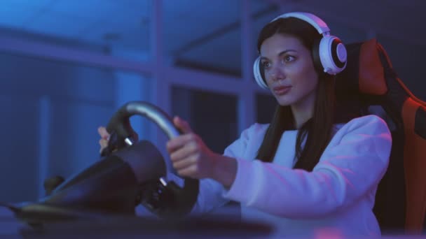 The gamer girl plays a racing video games in the dark room - Materiaali, video