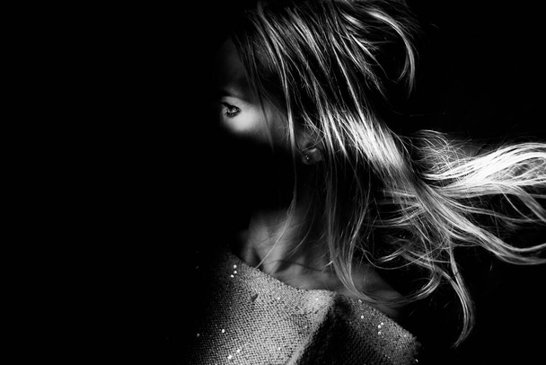 Το πορτρέτο μιας γυναίκας στις σκιές. Ασπρόμαυρη λήψη στούντιο. - Φωτογραφία, εικόνα