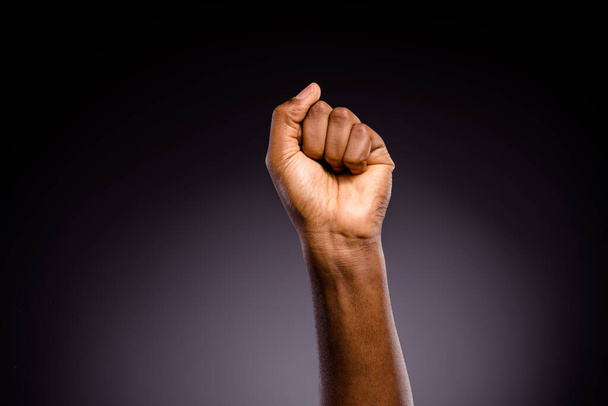 Close up photo of afro american hand raise fists ask support africká komunita stop discrimination isolated over black color background - Fotografie, Obrázek