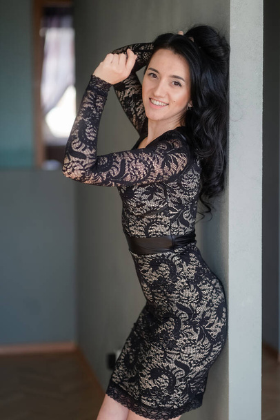 beautiful happy girl in a lace dress against the gray walls - Photo, image