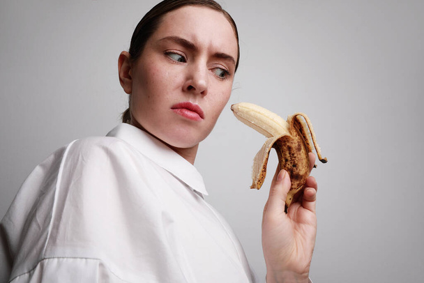Headshot young woman with banana. Safe sex concept photos. - 写真・画像