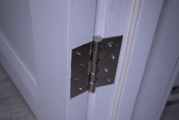 Zawiasy metalowe drzwi. Pokrętło elementów zbliżeniowych. lekkie drewniane drzwi w nowoczesnym stylu we wnętrzu - Zdjęcie, obraz