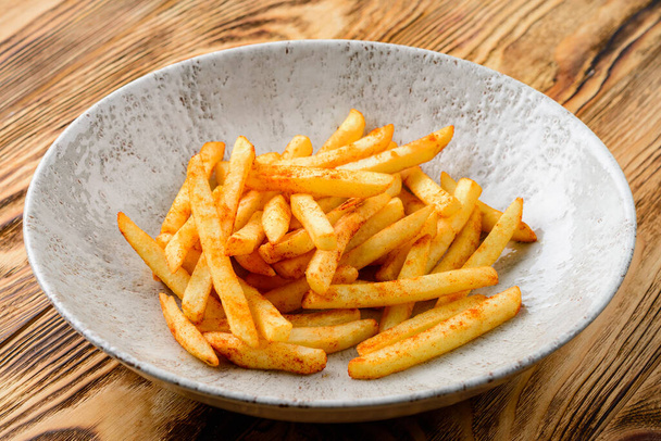 french fries in a plate on a wooden background - Fotografie, Obrázek