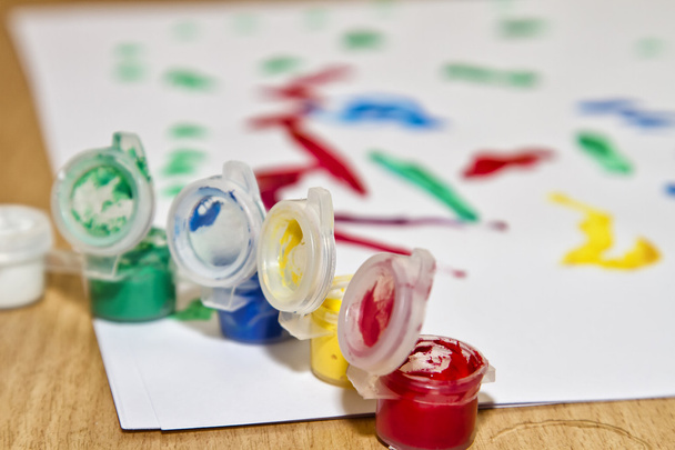Frascos multicolores con gouache y dibujo infantil
 - Foto, imagen