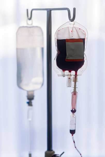 Запасные пакеты крови от лабораторной медицины, висящие на стальном столбе в больнице, чтобы подготовить кровь для вен пациентов, которые хотят сдать кровь в той же группе
 - Фото, изображение